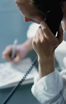 A picture of a man on the telephone taking notes